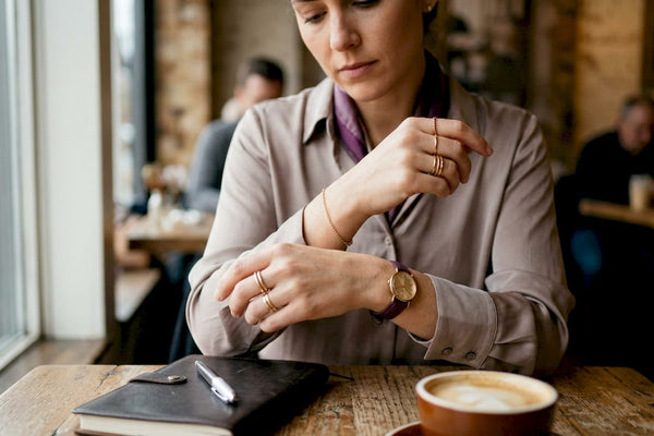 Close-up of hands fastening gold bracelet in office