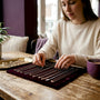 Woman arranging layered necklaces indoors