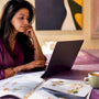 Woman browsing ethical jewelry on laptop at home