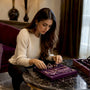 Woman arranging capsule jewelry pieces on tray