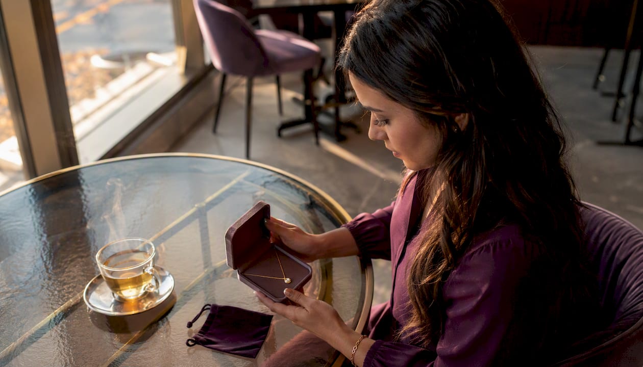Woman preparing milestone jewelry gift at home