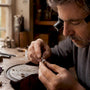 Jeweler securing moissanite stone with prongs