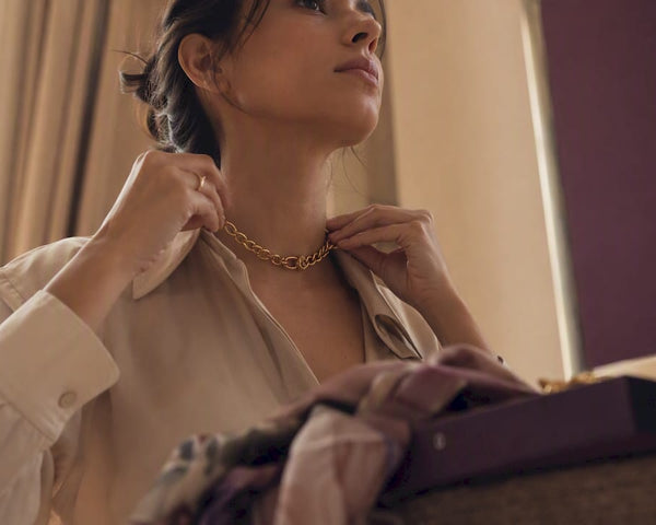 Woman adjusting chunky gold chain necklace