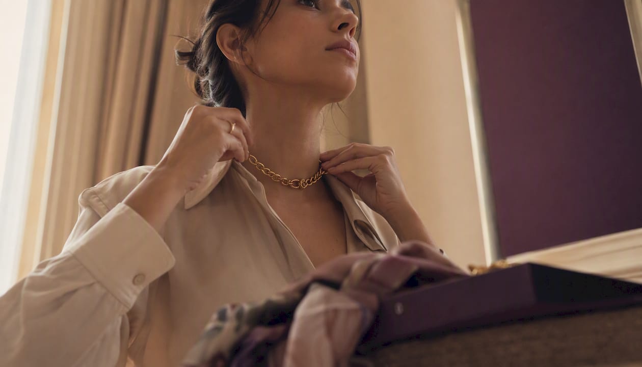 Woman adjusting chunky gold chain necklace