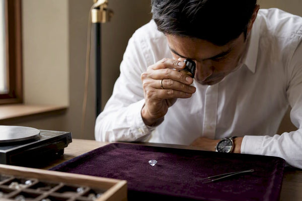 Hands calculating diamond price per carat