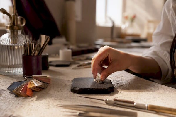 Hand placing moissanite ring on display pad