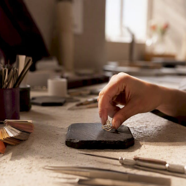 Hand placing moissanite ring on display pad