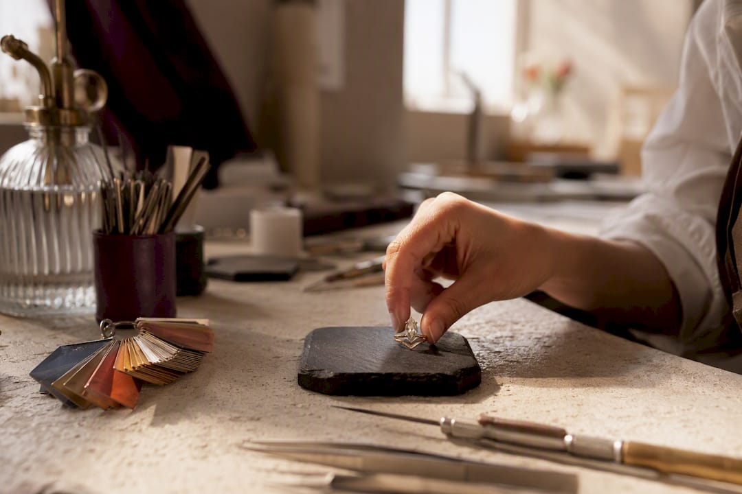 Hand placing moissanite ring on display pad