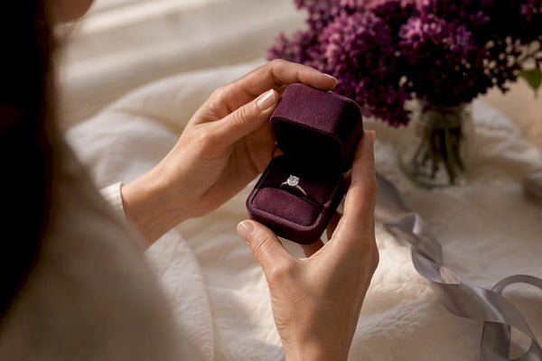 Hands opening moissanite ring box