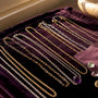 Layered necklaces on warm cream fabric