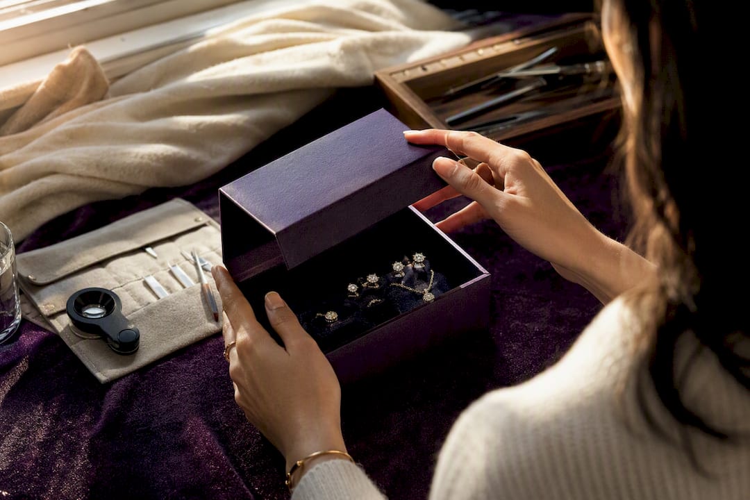 Hands opening jewelry subscription box with moissanite