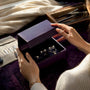 Hands opening jewelry subscription box with moissanite