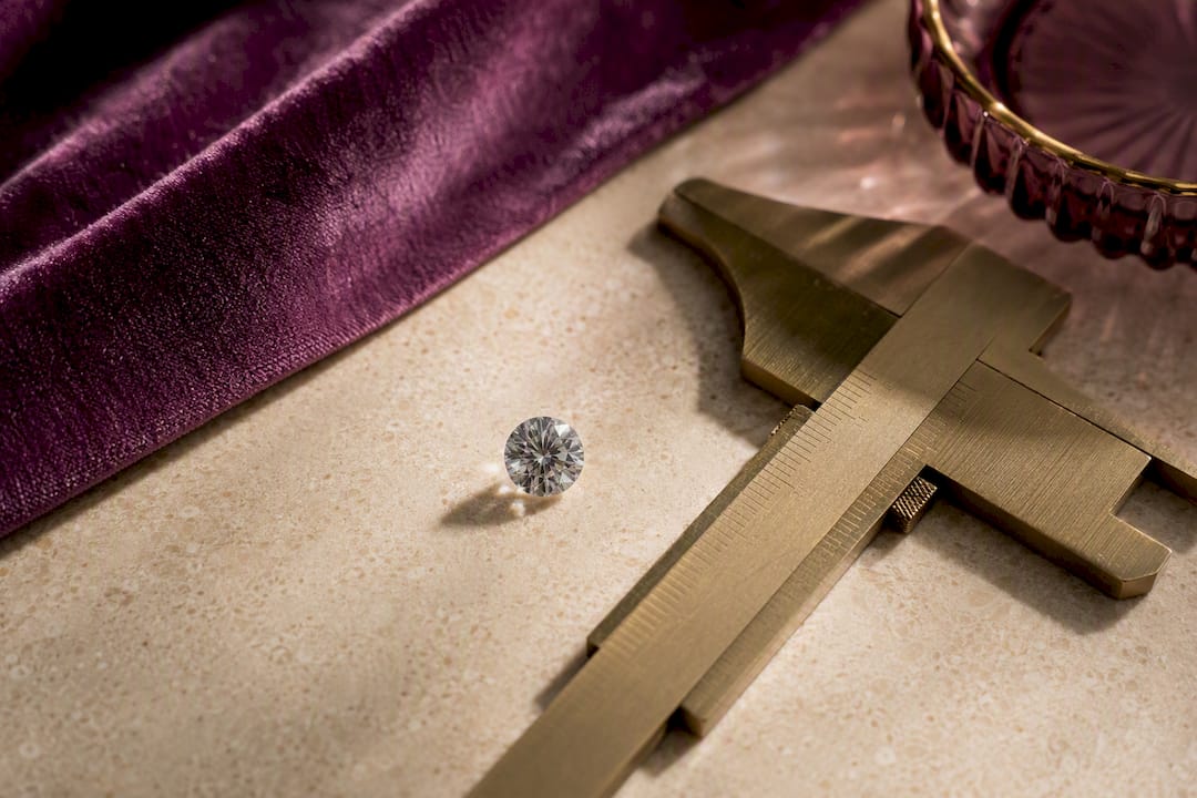 Moissanite gemstone beside millimeter gauge