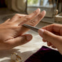 Hands checking ring size with metal gauge