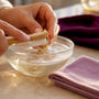 Hands gently cleaning gold jewelry at home