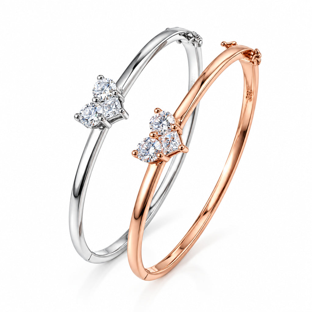 Two diamond-studded bangles, one silver and one rose gold, on a light background.