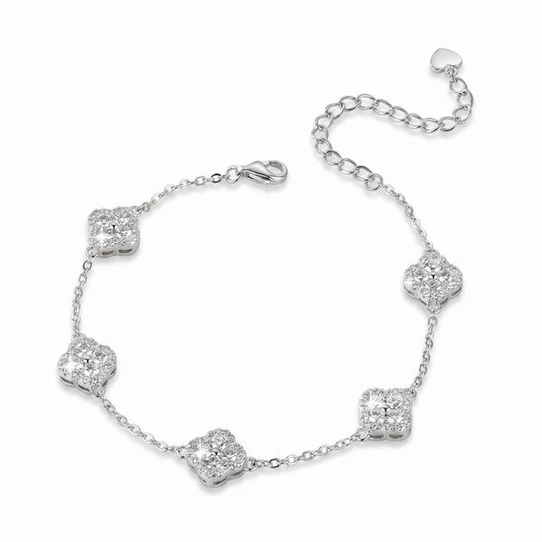 A silver chain bracelet featuring five pavé-set clear stones arranged in a floral clover pattern, with a lobster clasp and an adjustable extender chain with a heart-shaped tag, shown on a plain white background.