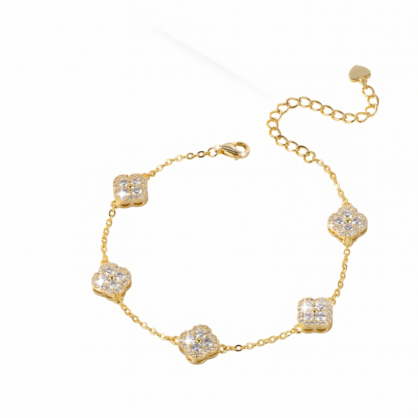 A gold chain bracelet featuring five alternating clover-shaped and square motifs paved with clear stones, displayed on a clean white background.